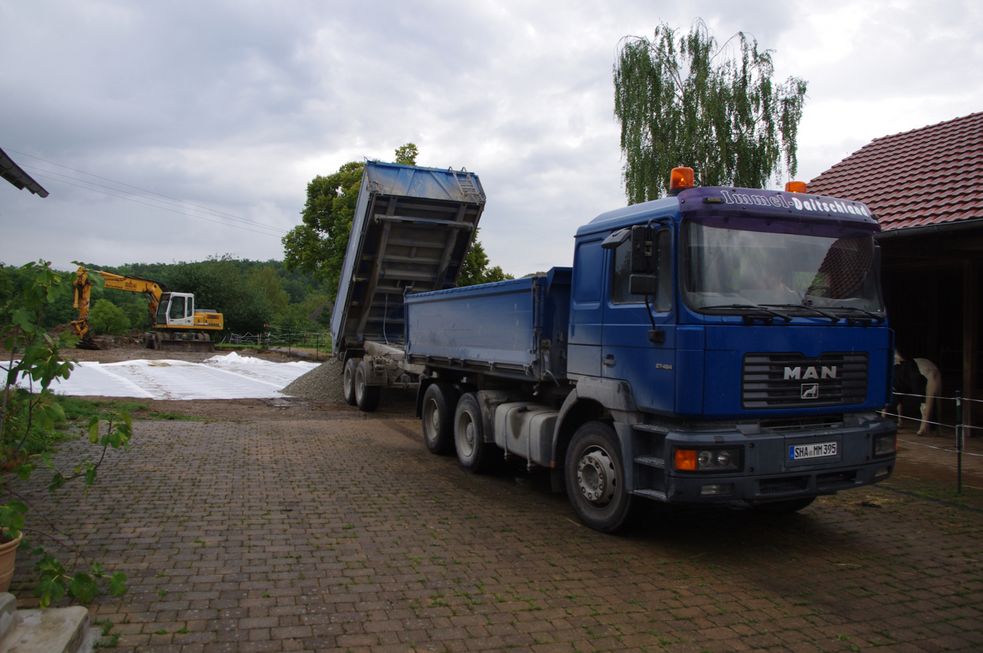 LKW kippt Mineral für den Reitplatz ab