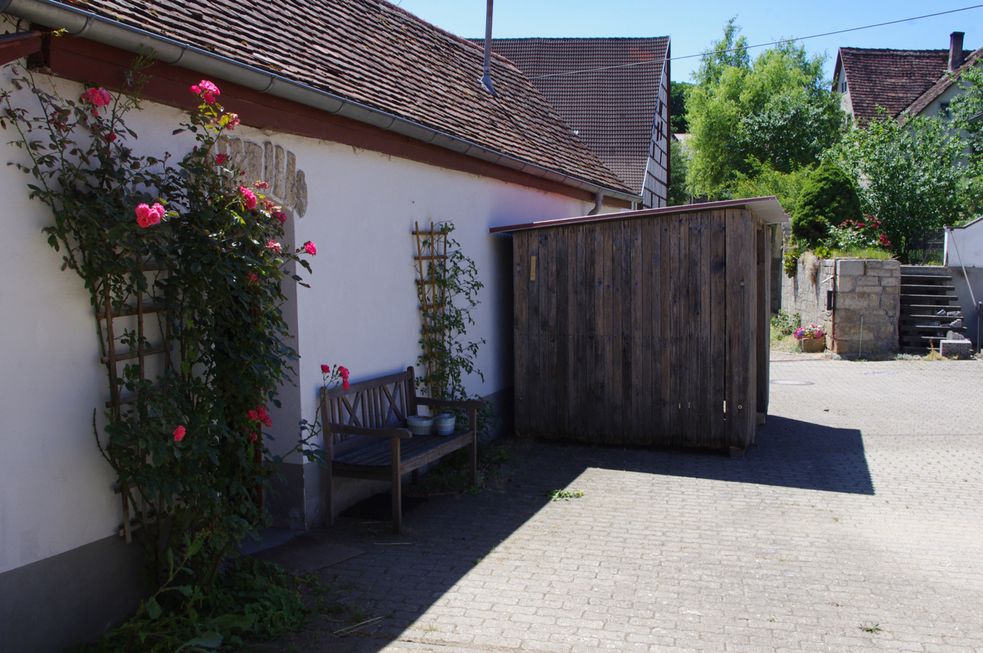 Shetty-Hütte von der Seite mit Rosen im Vordergrund