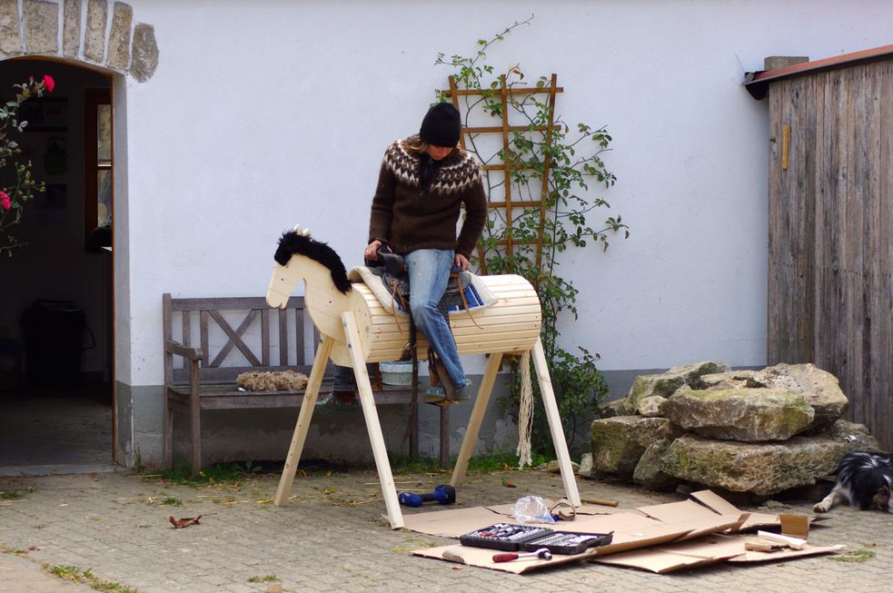 Sattel- und Sitztest auf dem Pferd aus Holz