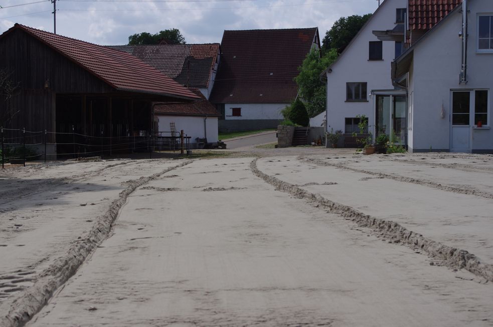 Reitplatz nachdem der Sand eingeebnet wurde, Foto mit Blick auf Hof und Offenstall